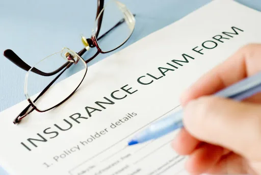 person filling out insurance claim form